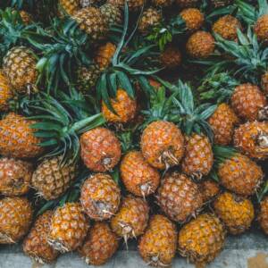 A vibrant display of ripe pineapples at a tropical outdoor market, showcasing freshness.
